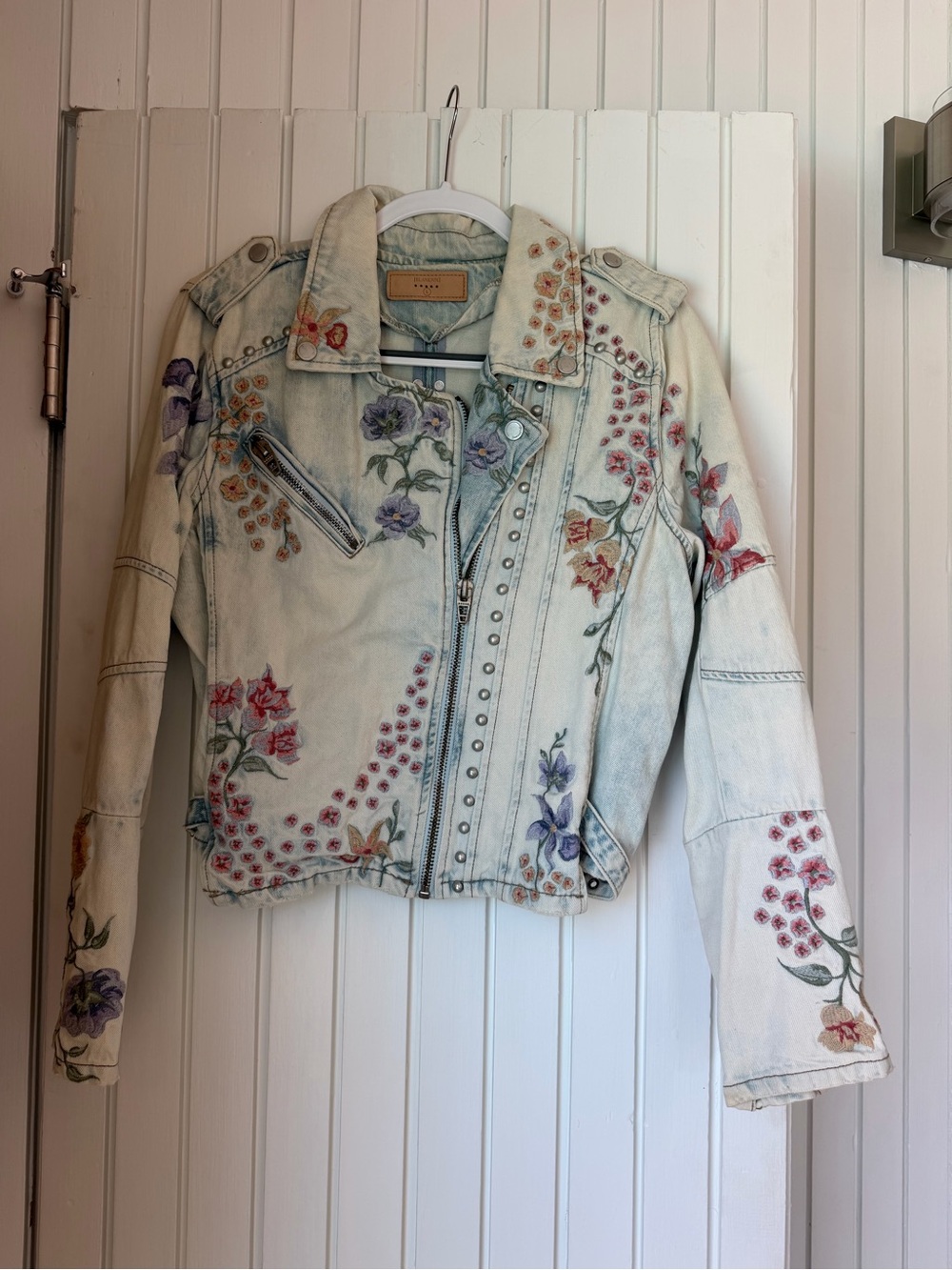Blank NYC Light Wash Denim Moto Jacket with Multicolor Floral Embroidery & Studs